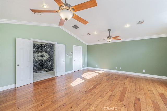 empty room featuring vaulted ceiling, ornamental molding, and light hardwood / wood-style flooring