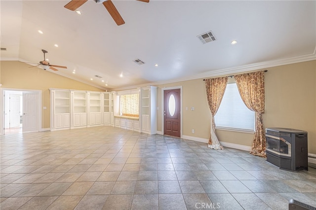 foyer featuring vaulted ceiling, a wood stove, a wealth of natural light, and ornamental molding