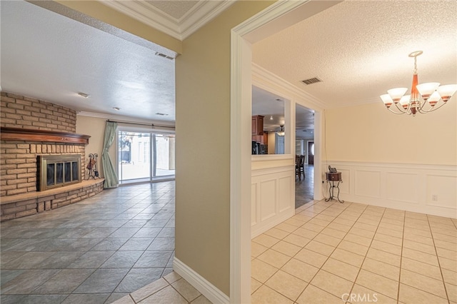 interior space with a notable chandelier, crown molding, light tile patterned floors, and a textured ceiling