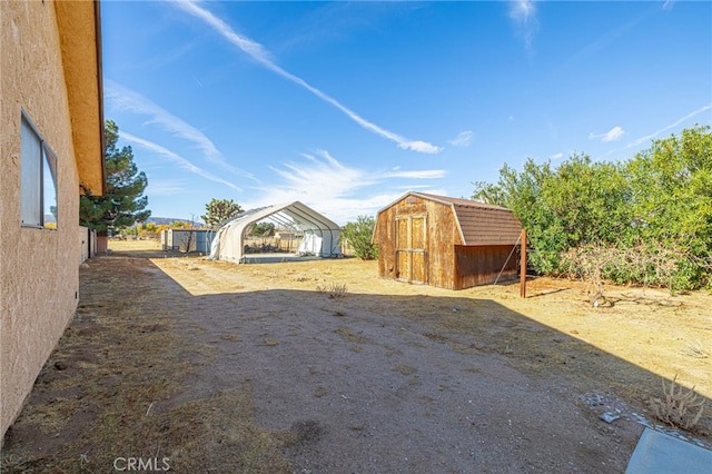 view of yard with a carport and a storage unit