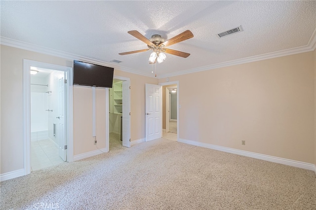 unfurnished bedroom featuring a walk in closet, ceiling fan, a textured ceiling, connected bathroom, and a closet