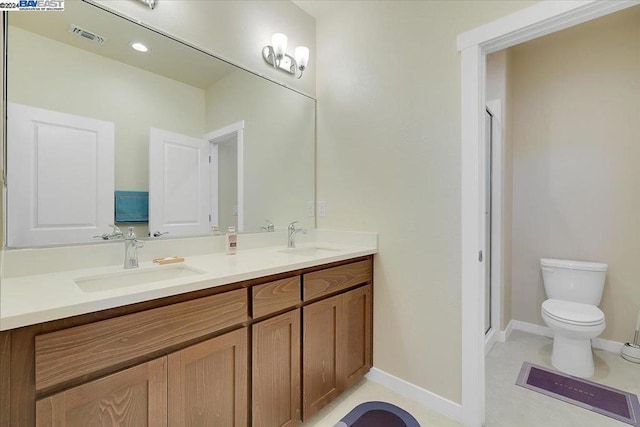 bathroom with vanity, a shower with shower door, and toilet