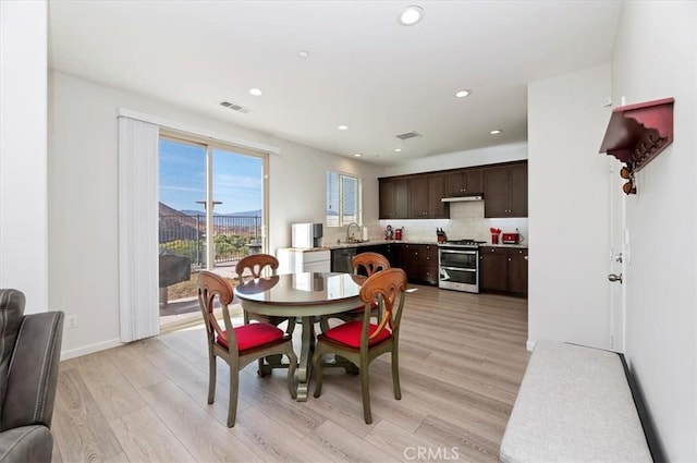 dining room with sink and light hardwood / wood-style flooring