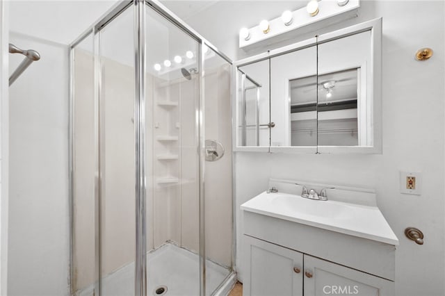 bathroom featuring vanity and a shower with door