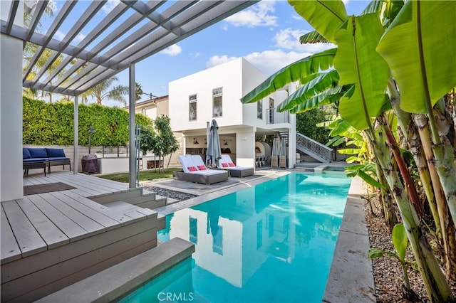 view of pool with an outdoor living space and a deck