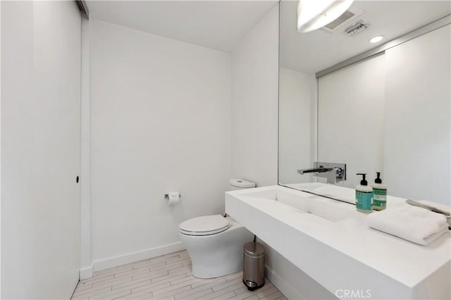 bathroom with toilet and wood-type flooring