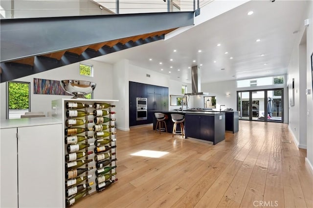 interior space featuring island range hood, stainless steel microwave, and light wood-type flooring