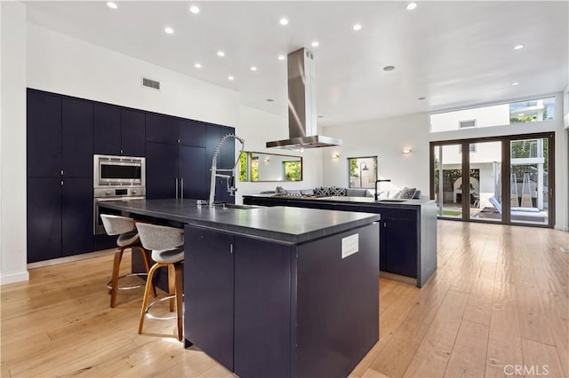 kitchen featuring island range hood, a spacious island, sink, and appliances with stainless steel finishes