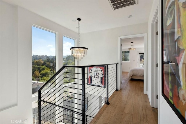 corridor featuring hardwood / wood-style floors and a chandelier