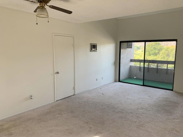 unfurnished room featuring ceiling fan, light colored carpet, and a textured ceiling