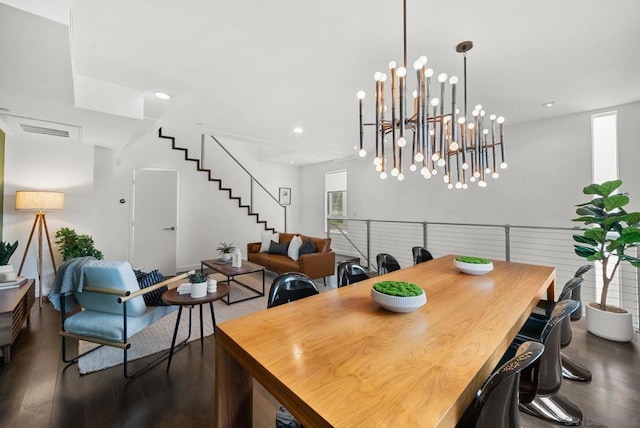 dining space featuring dark wood-type flooring and a notable chandelier