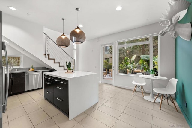 kitchen featuring hanging light fixtures, a center island, light tile patterned flooring, and stainless steel dishwasher