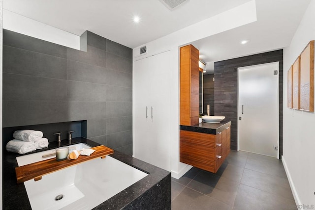 bathroom featuring tile patterned flooring, vanity, and tile walls