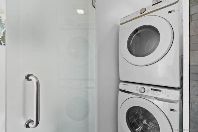 clothes washing area with stacked washer and dryer