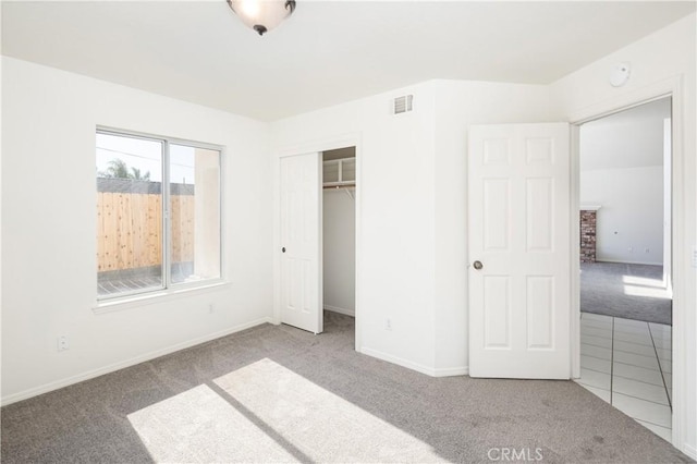 unfurnished bedroom with light colored carpet and a closet