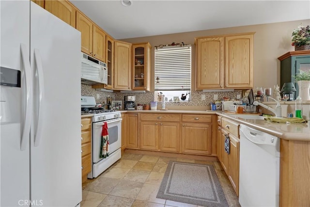 kitchen with light brown cabinetry, white appliances, tasteful backsplash, and sink