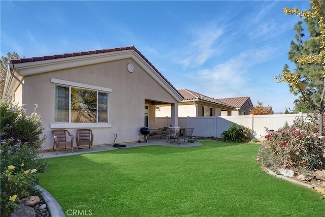 rear view of property with a lawn and a patio