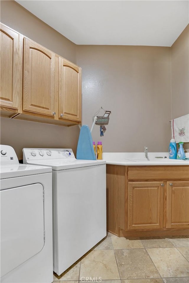 laundry room featuring cabinets, independent washer and dryer, and sink