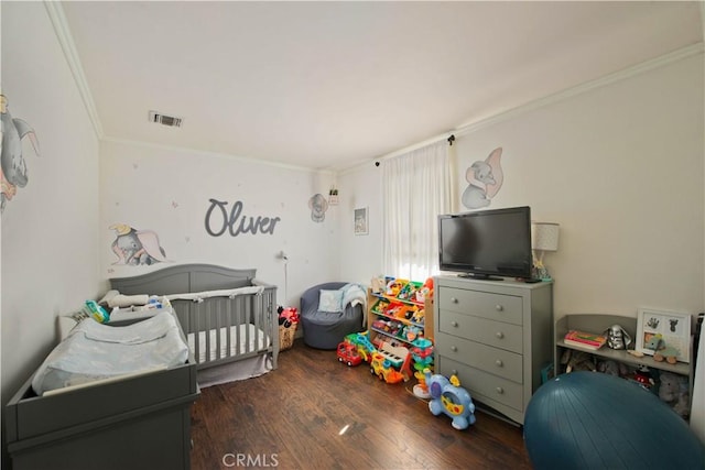 bedroom with crown molding, dark hardwood / wood-style flooring, and a nursery area