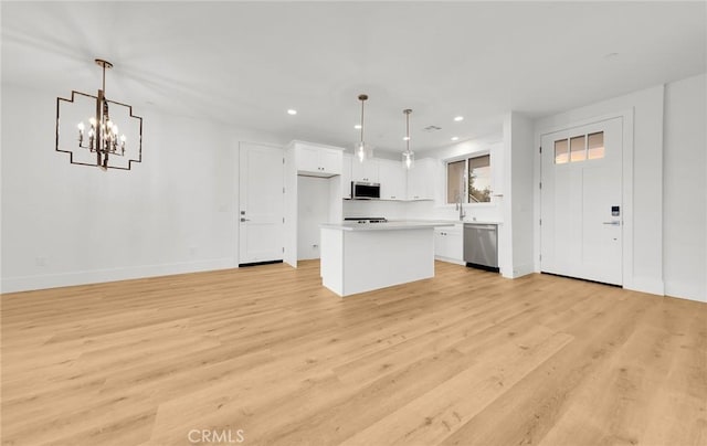 kitchen featuring pendant lighting, appliances with stainless steel finishes, a center island, and white cabinets