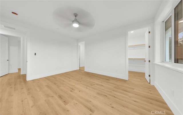 empty room with ceiling fan and light hardwood / wood-style flooring