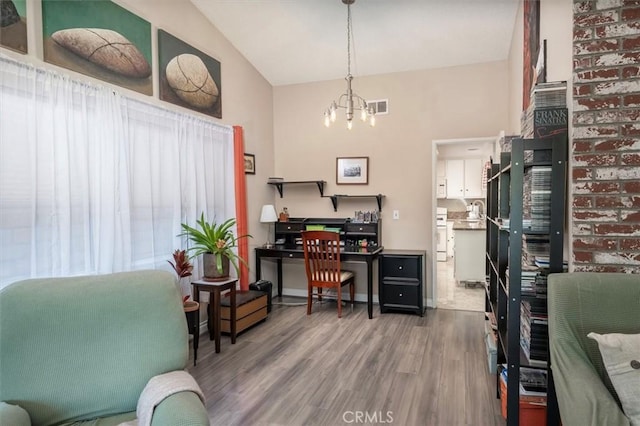 home office with wood-type flooring, high vaulted ceiling, and an inviting chandelier