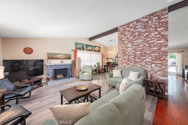 living room with a chandelier, lofted ceiling with beams, a fireplace, and wood-type flooring