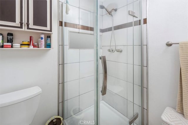 bathroom with toilet and a shower with door