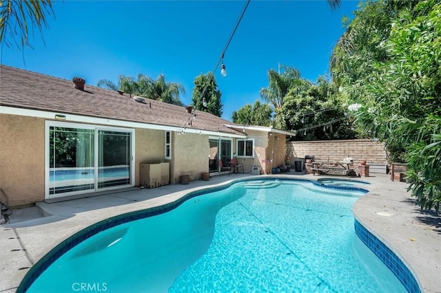 view of swimming pool featuring a patio area and an in ground hot tub