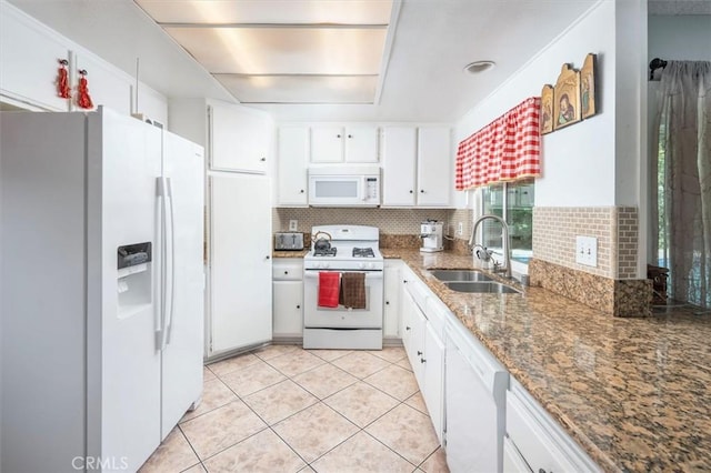 kitchen featuring tasteful backsplash, white appliances, sink, dark stone countertops, and white cabinetry