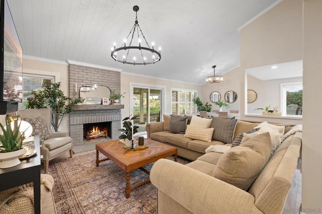 living room with an inviting chandelier, a brick fireplace, wood-type flooring, vaulted ceiling, and ornamental molding