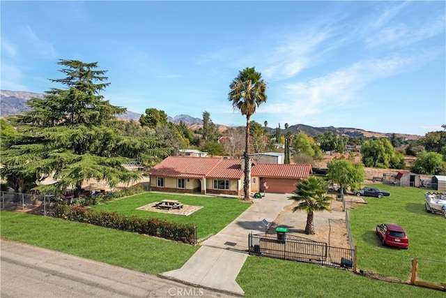 view of front of property with a mountain view, a garage, and a front yard