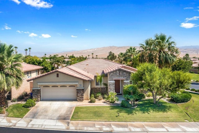 mediterranean / spanish house featuring a mountain view, a garage, and a front yard