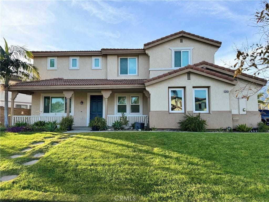 mediterranean / spanish house featuring covered porch and a front yard