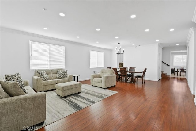 living room with dark hardwood / wood-style flooring, an inviting chandelier, and ornamental molding