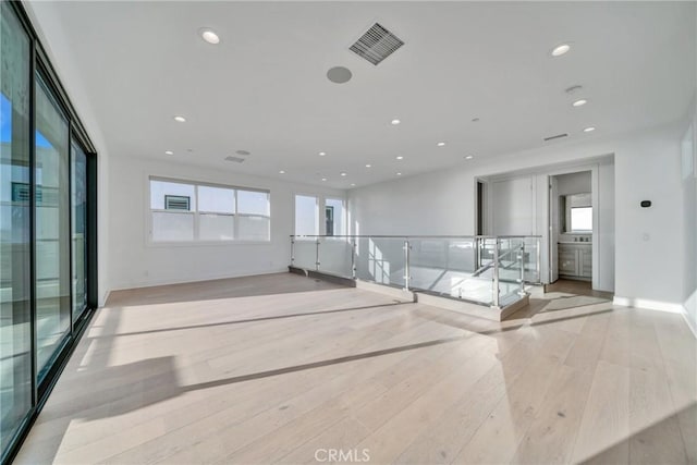 spare room with a healthy amount of sunlight and light hardwood / wood-style floors