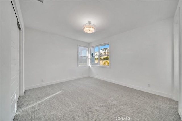 spare room featuring light colored carpet