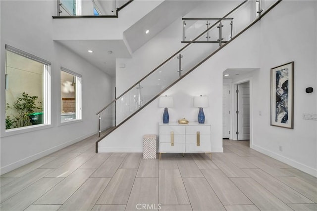 living room featuring light wood-type flooring and a towering ceiling