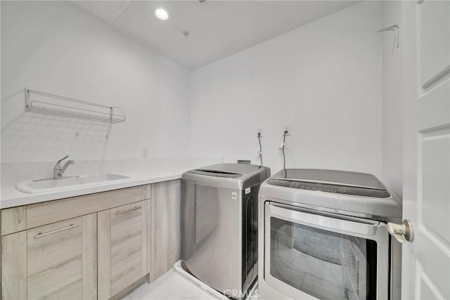 clothes washing area with cabinets, independent washer and dryer, and sink