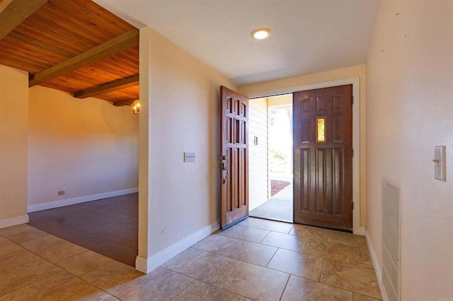 tiled entrance foyer featuring beamed ceiling and wooden ceiling