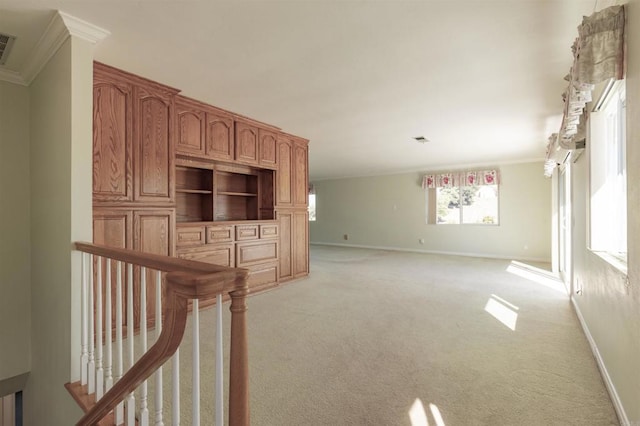 unfurnished living room featuring ornamental molding and light carpet