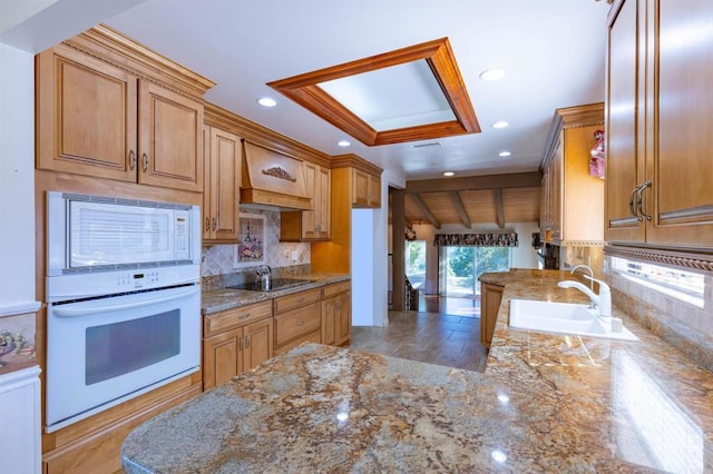 kitchen featuring white appliances, premium range hood, sink, tasteful backsplash, and beam ceiling