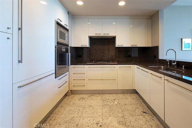 kitchen featuring white cabinets, decorative backsplash, sink, and stainless steel appliances