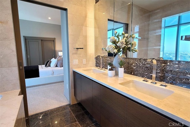 bathroom featuring vanity, a healthy amount of sunlight, and tile walls