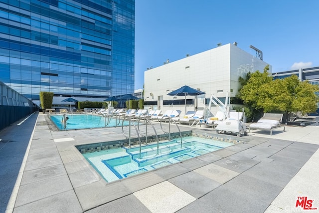 view of swimming pool featuring a community hot tub and a patio area