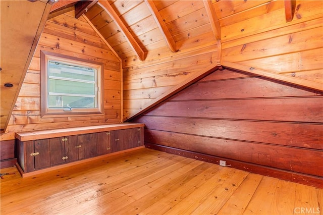 bonus room with light wood-type flooring, wooden ceiling, vaulted ceiling with beams, and wooden walls