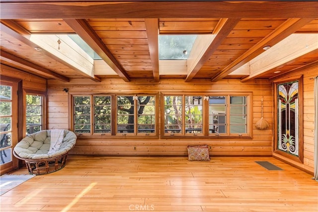 sunroom / solarium with beam ceiling, a skylight, and wooden ceiling