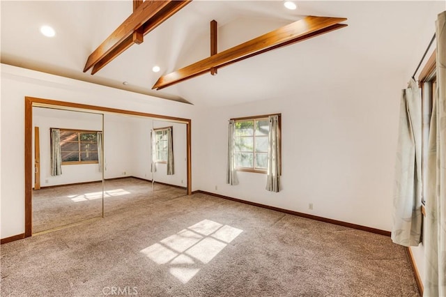 unfurnished bedroom with carpet floors, a closet, high vaulted ceiling, and beam ceiling