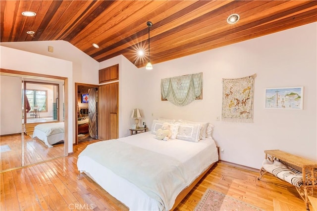 bedroom with a closet, vaulted ceiling, wooden ceiling, and light hardwood / wood-style flooring