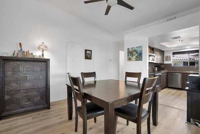 dining area with ceiling fan, light wood-type flooring, and sink